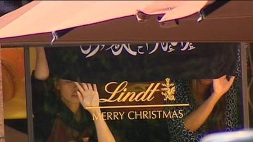 Hostages inside Sydney Cafe hold up Islamic Flag