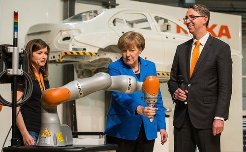 Chancellor Angela Merkel tries out a robotic arm during her visit to the KUKA industrial robotics factory on March 13, 2015, in Augsburg, Germany.